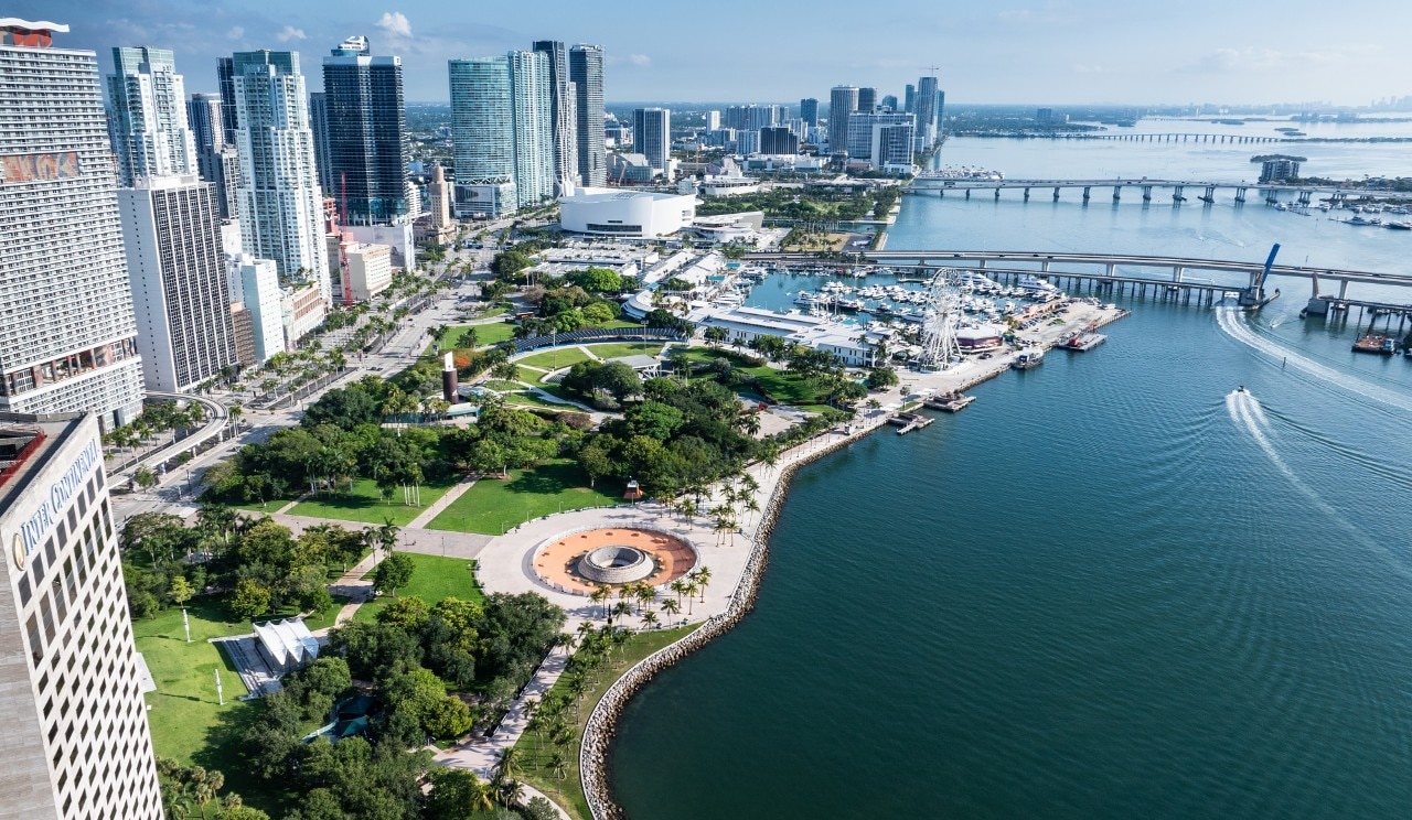 This aerial drone shot of Miami and Biscayne Bay allows us to see into the many aspects of Miami lifestyle and the options for entertainment when travelling.  There is a massive condominium complex, harbors with countless boats and yachts, a beautiful boardwalk, and so much entertainment.  In this photo alone, we see a huge ferris wheel on the boardwalk, as well as jetskis cruising around the bay.  Not to mention the multiple islands connecting to Miami's stunning cityscape full of skyscrapers.
