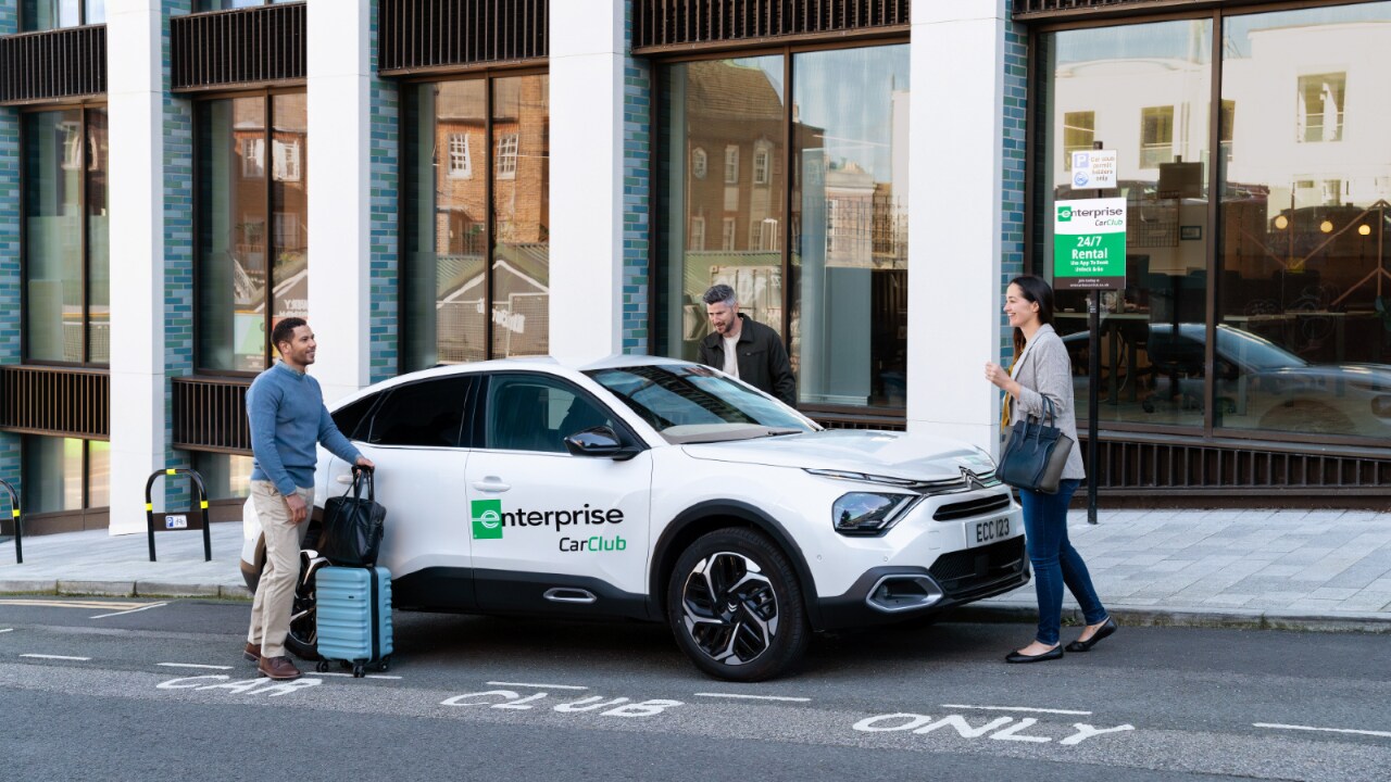 Trois personnes montent dans un véhicule Enterprise car Club.