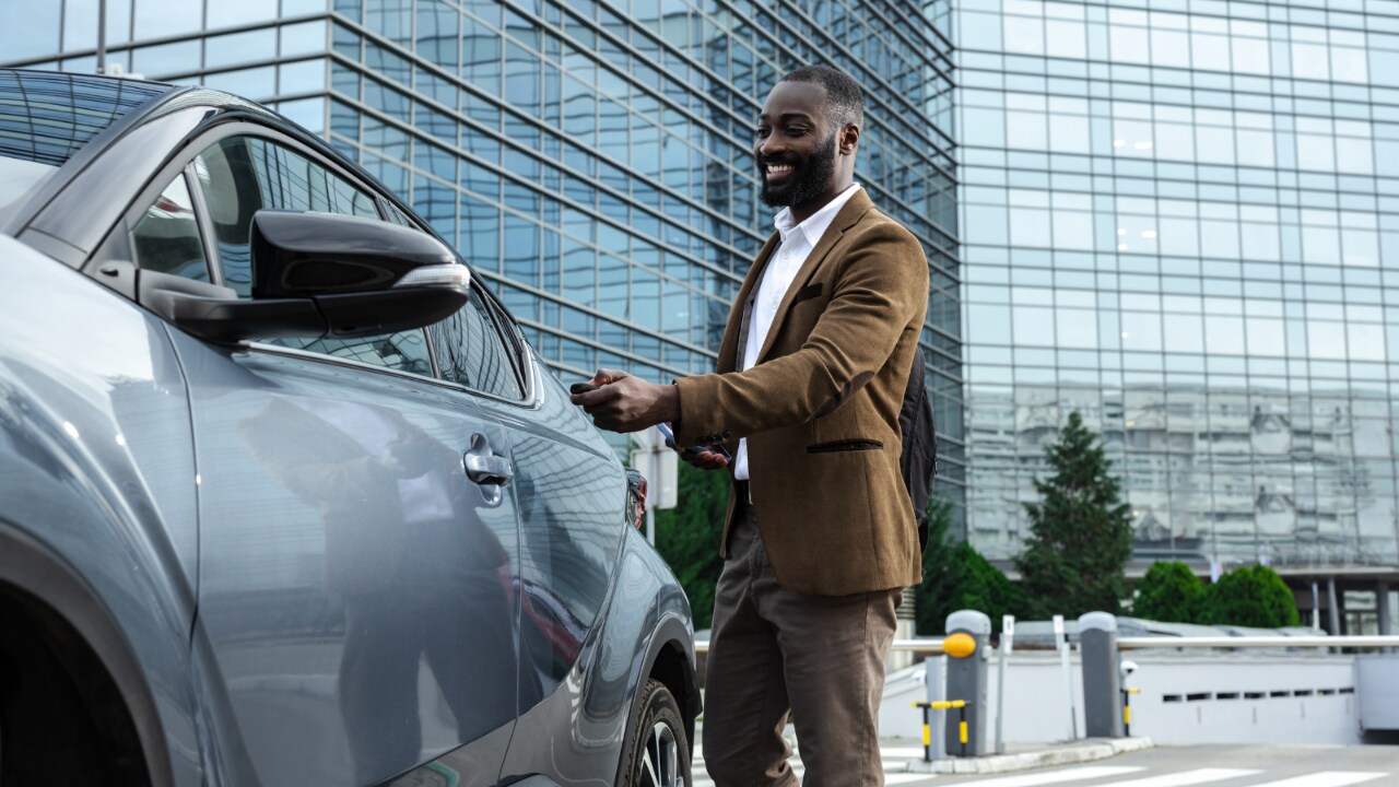 Homme qui monte dans sa voiture après une journée de travail.