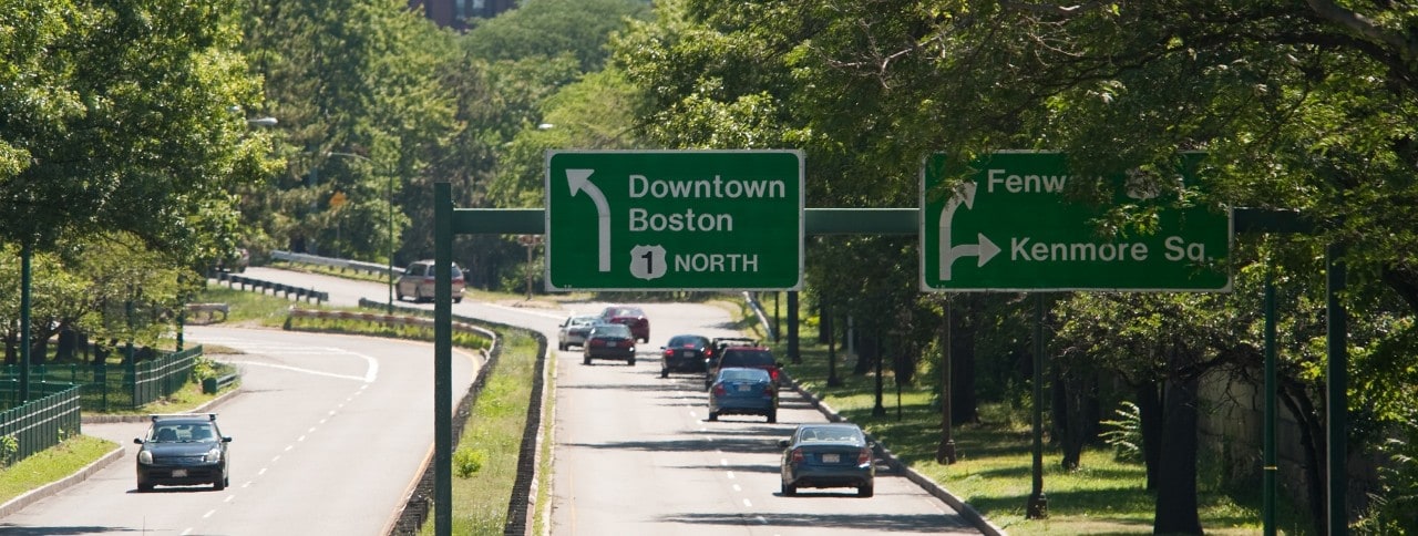 A common site for thousands of college bound students.  Traffic signs pointing the way to Boston and Kenmore Square on Storrow Drive